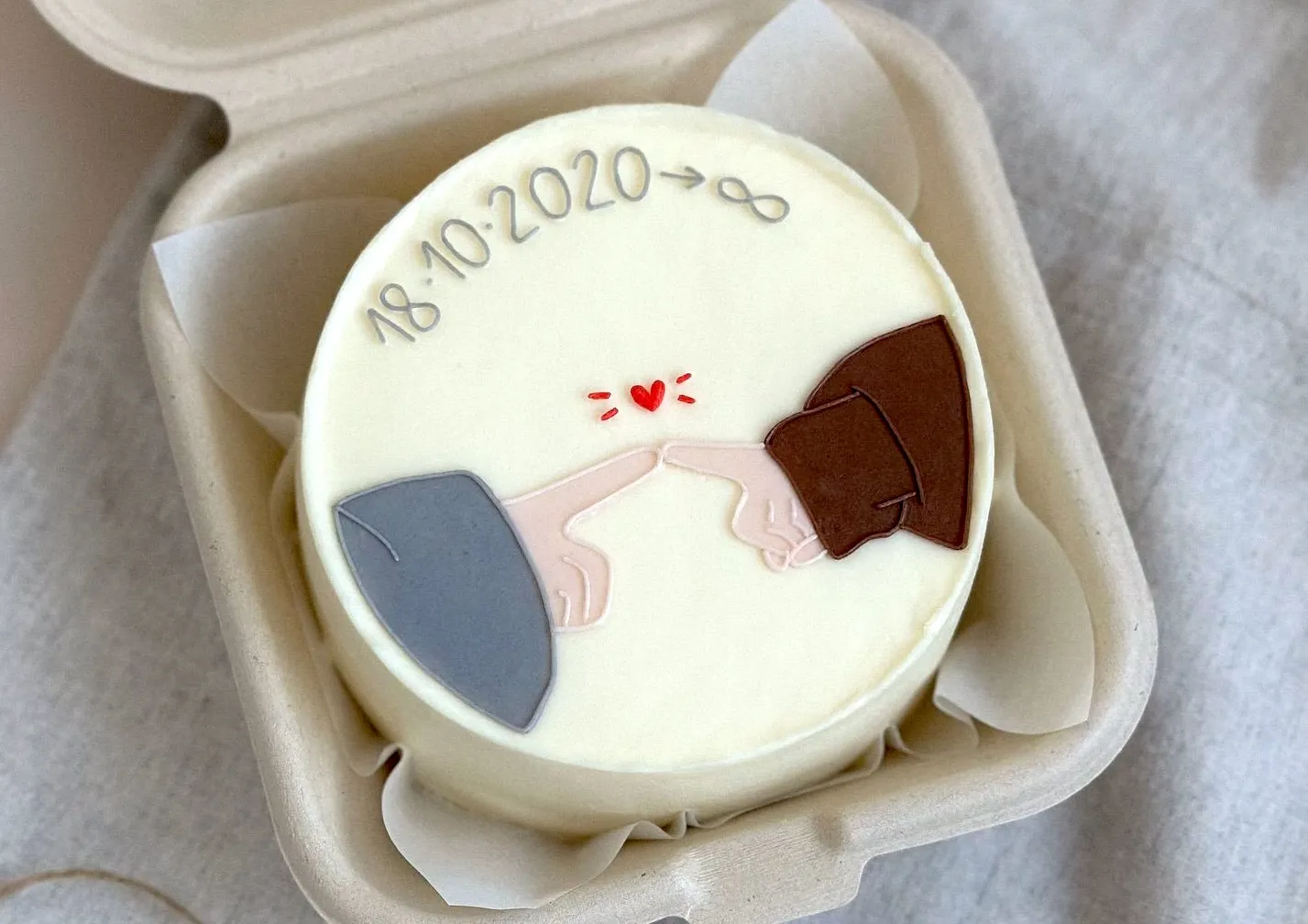 Bento cake with two hands touching fingers, a tiny red heart and a date followed by an infinity sign