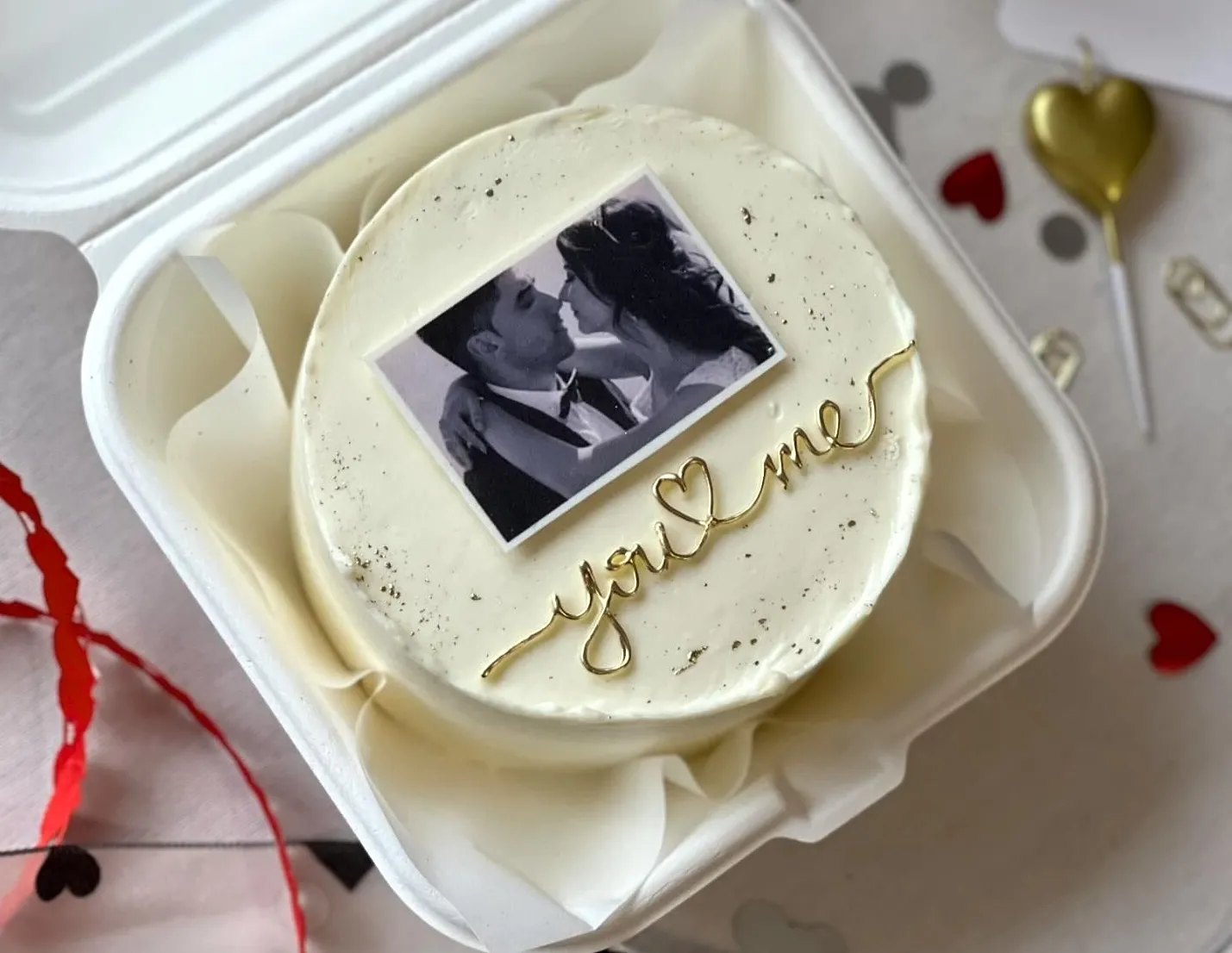 Bento cake in a lunch box with a black and white couple photo and gold You and Me lettering with a heart