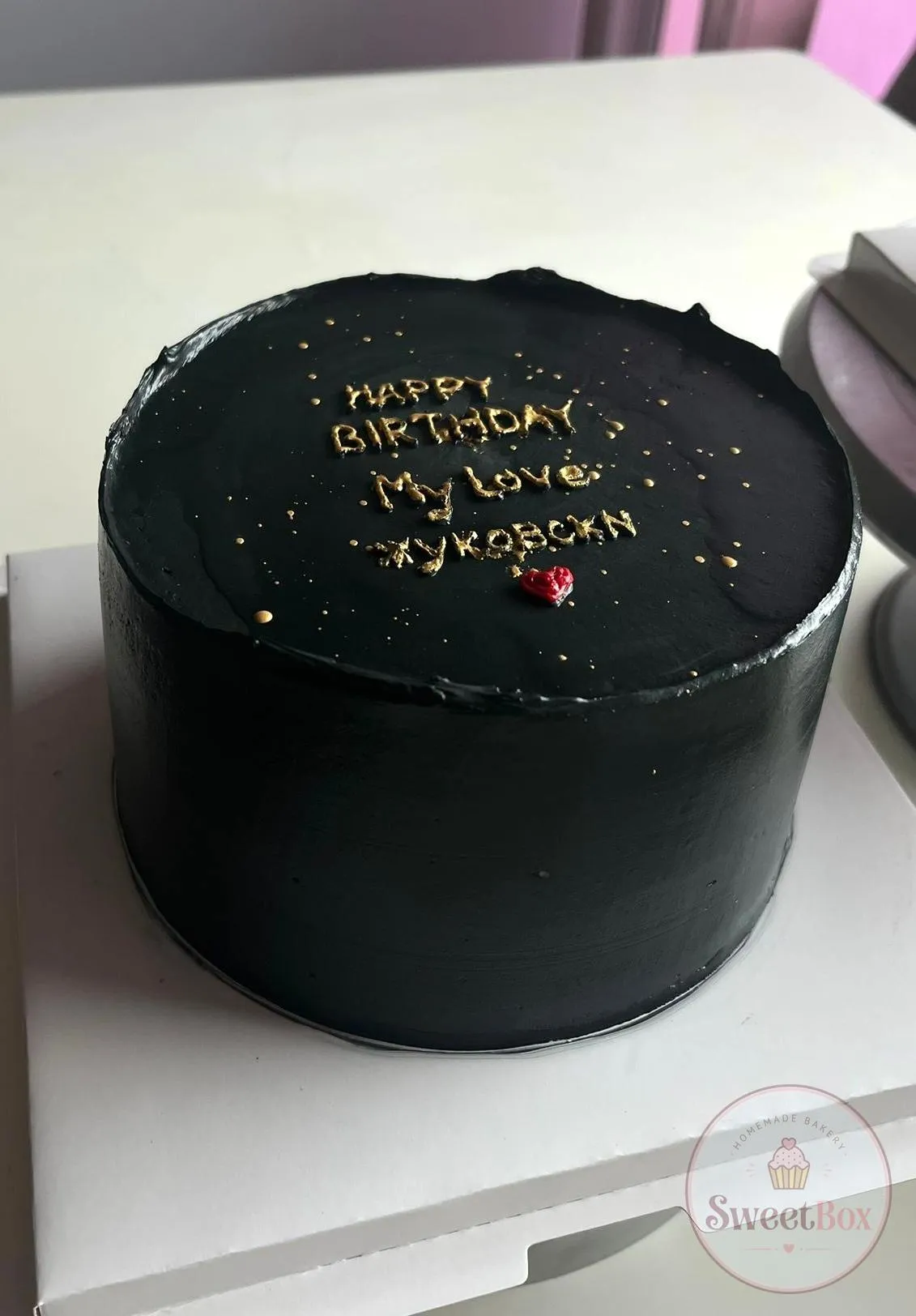 Matte black minimalist cake with a gold Happy Birthday My Love message and a tiny red heart