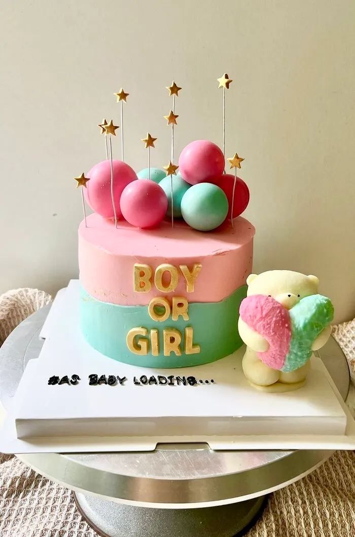 Two-tone pink and mint Boy or Girl cake with gold star picks, pastel balls and a fluffy bear figure