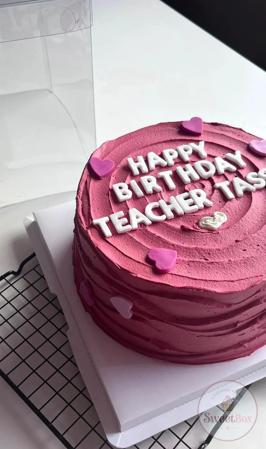 Magenta textured cake with white Happy Birthday Teacher letters and small pink hearts
