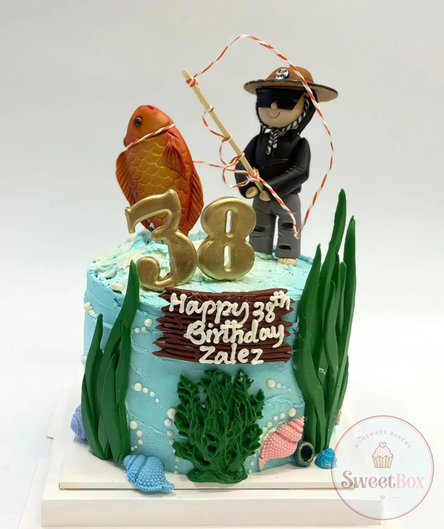 Underwater fishing cake with a fisherman figurine, goldfish, seaweed and a gold number 38