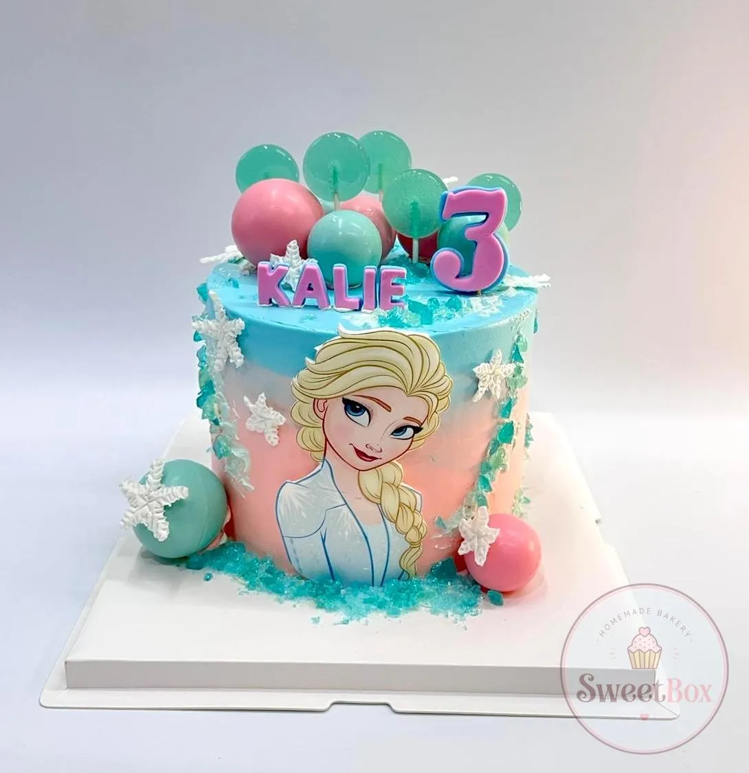 Frozen Elsa third birthday cake with pastel balls, lollipops and a personalized name topper