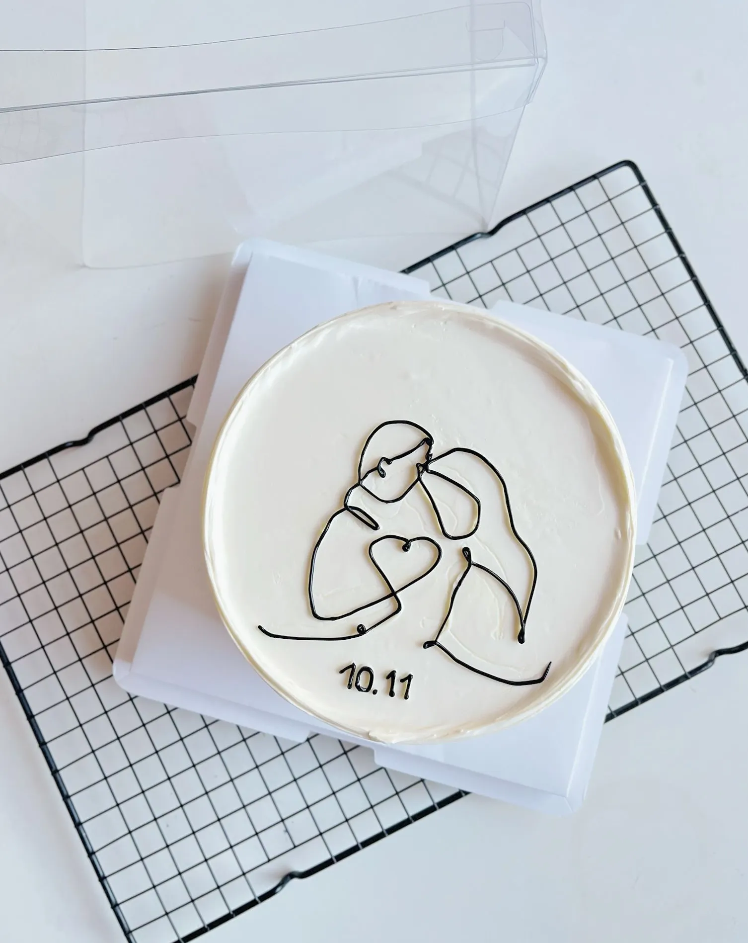 Minimalist bento cake with a black line drawing of a hugging couple and a heart