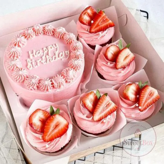 Pink Happy Birthday bento cake with piped border and pink cupcakes topped with fresh strawberries
