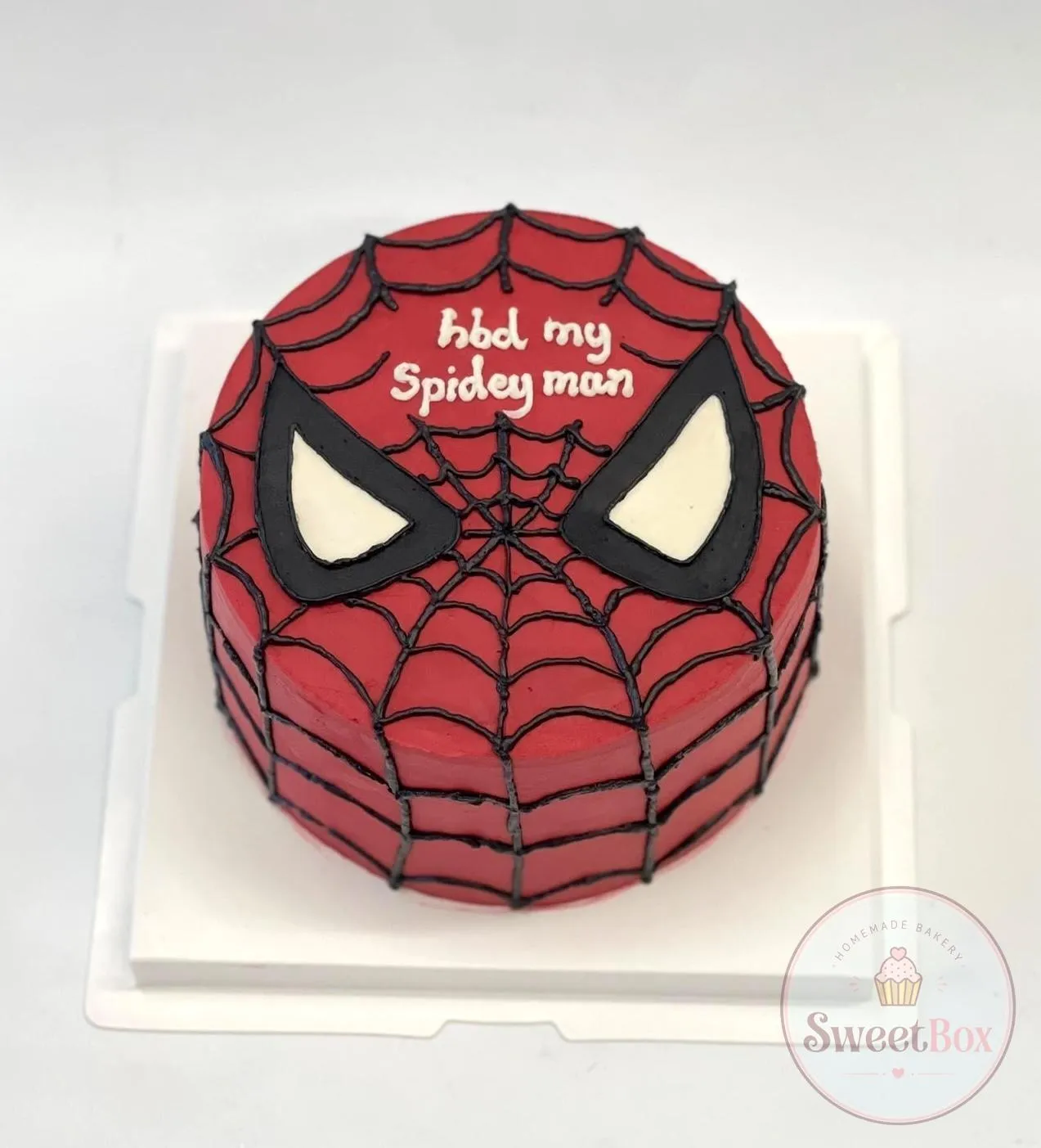 Red bento cake piped as a Spider-Man mask with black web lines and a hbd my Spidey man message