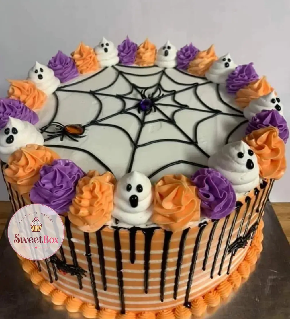 Orange striped cake with a black piped spiderweb, two spiders, a black drip and piped ghosts between orange and purple rosettes