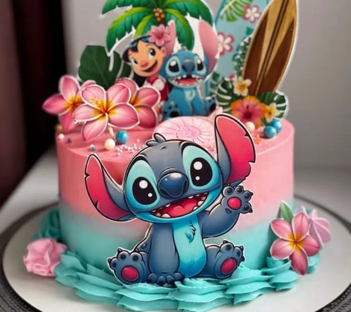 Pink and teal Lilo and Stitch cake with tropical frangipani flowers, palm tree and surfboard toppers