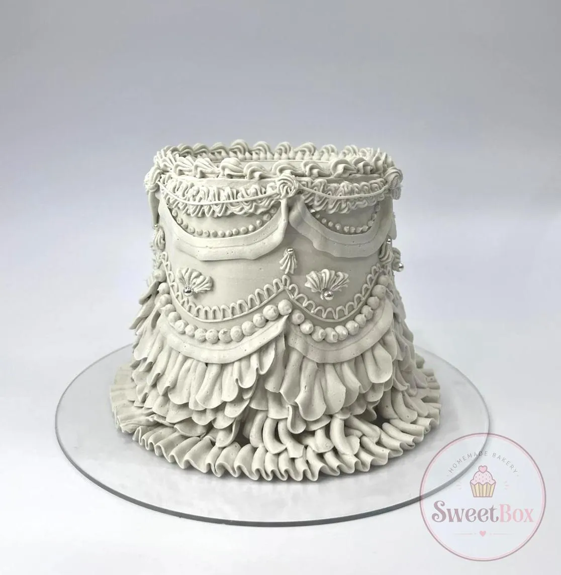 Tall pale gray vintage cake with sculpted drapes, pearl beading and cascading ruffles
